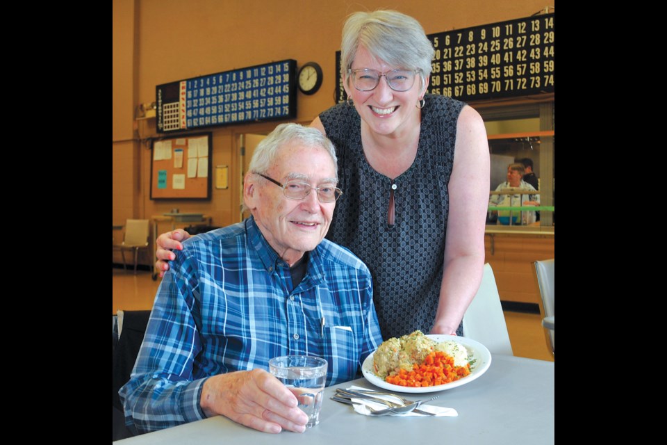 Silver Harbour Seniors' Activity Centre executive director Annwen Loverin serves some lunch to Hugh Mitchell. | Paul McGrath / North Shore News 