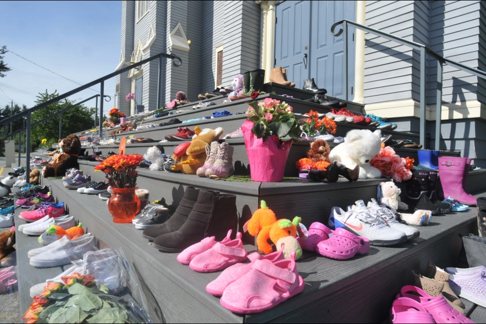 Dozens of children's shoes line the stairs of St. Paul's Church in the Squamish Nation community of Eslhá7an, Mission reserve, on Monday, May 31, 2021, in honour of the children buried at Kamloops Residential School.