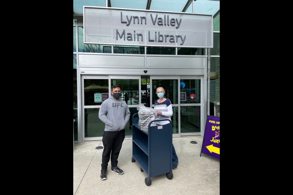 Powerlifter Sumeet Sharma makes a food donation to workers at the Lynn Valley library. 