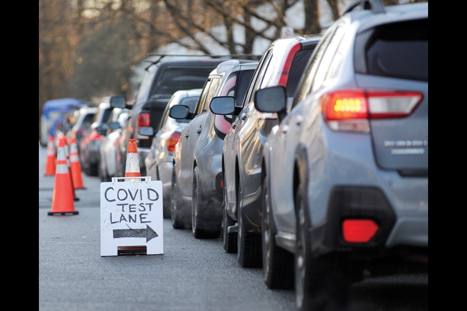 Cars line up at the COVID-19 testing centre on Lloyd Avenue in North Vancouver Monday morning, Dec. 20.