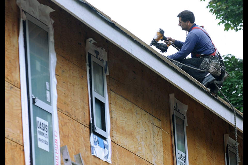 A roofer completes some work on a North Shore house. 