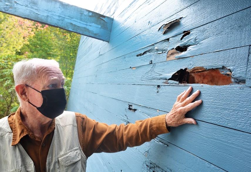 Peter Phelan, 89, shows holes in the exterior wall of Silverlynn Apartments. BC Housing and the Lowland Senior Citizens Housing Society say repairs are coming.