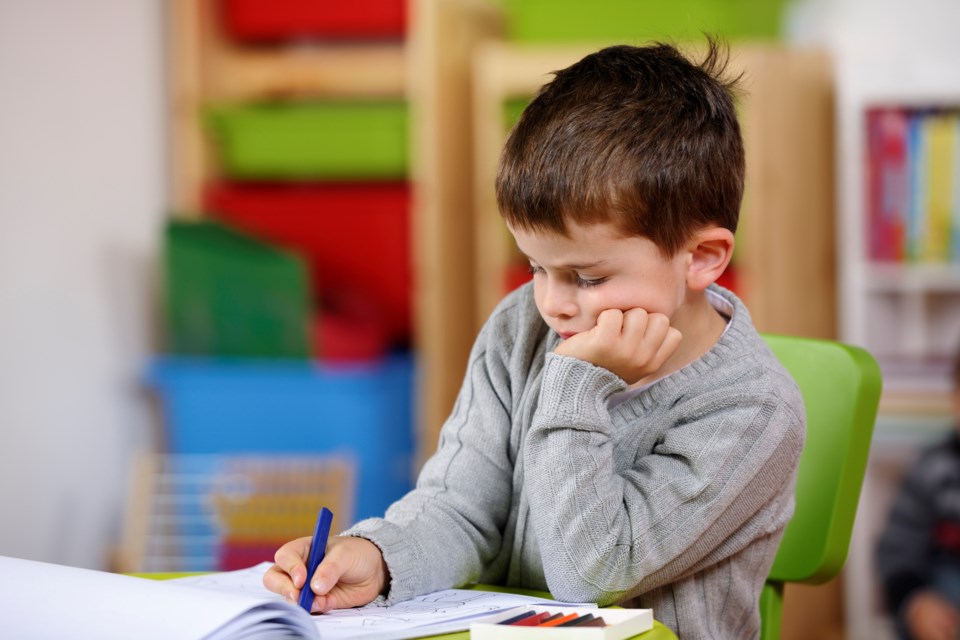 boy colouring at school