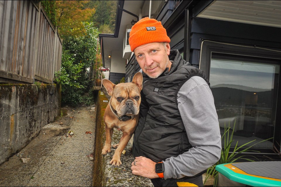 Panorama Drive resident David Goodman and dog Tiller are happy to be back home after his residence flooded in the atmospheric river storm. Goodman said there were no emergency accommodations on the North Shore that accept pets. | Paul McGrath / North Shore News