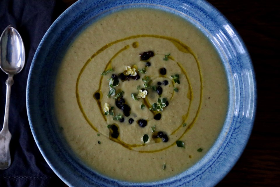 Antioxidant rich blueberries and olive oil garnish nutrient dense roasted leek, potato and arugula soup.