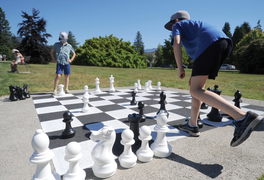 Luc and Simon, aged 10 and 8, challenge each other on the renovated  chess board at Grand Boulevard Park.