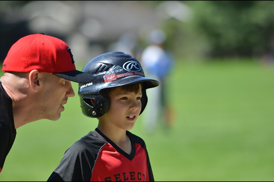 Greg Gowe coaches his son Micah during a Highlands Little League game in North Vancouver. 