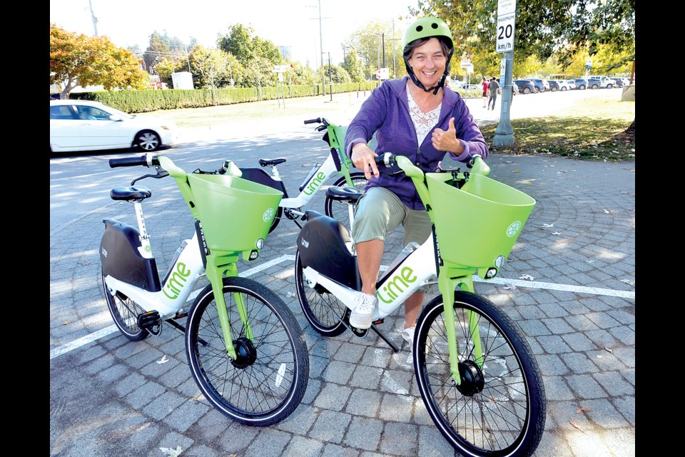 West Vancouver councillor Nora Gambioli at the Lime bike nest at Argyle Avenue and 13th Street. The elected official said she was impressed by the number of people borrowing the bikes over the past year.