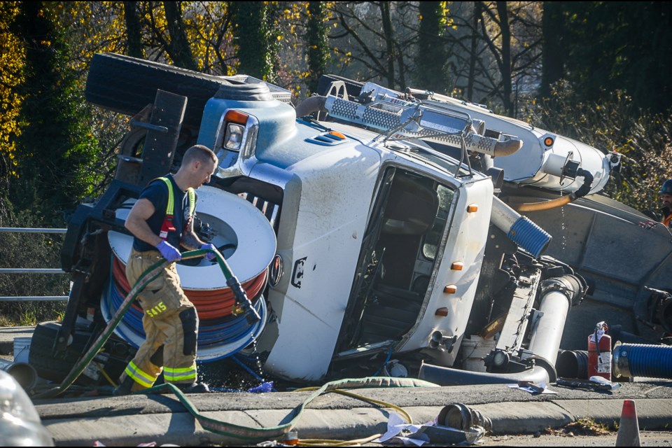 Crews work to clean up the scene surrounding a flipped vacuum truck on Mountain Highway Nov. 17.