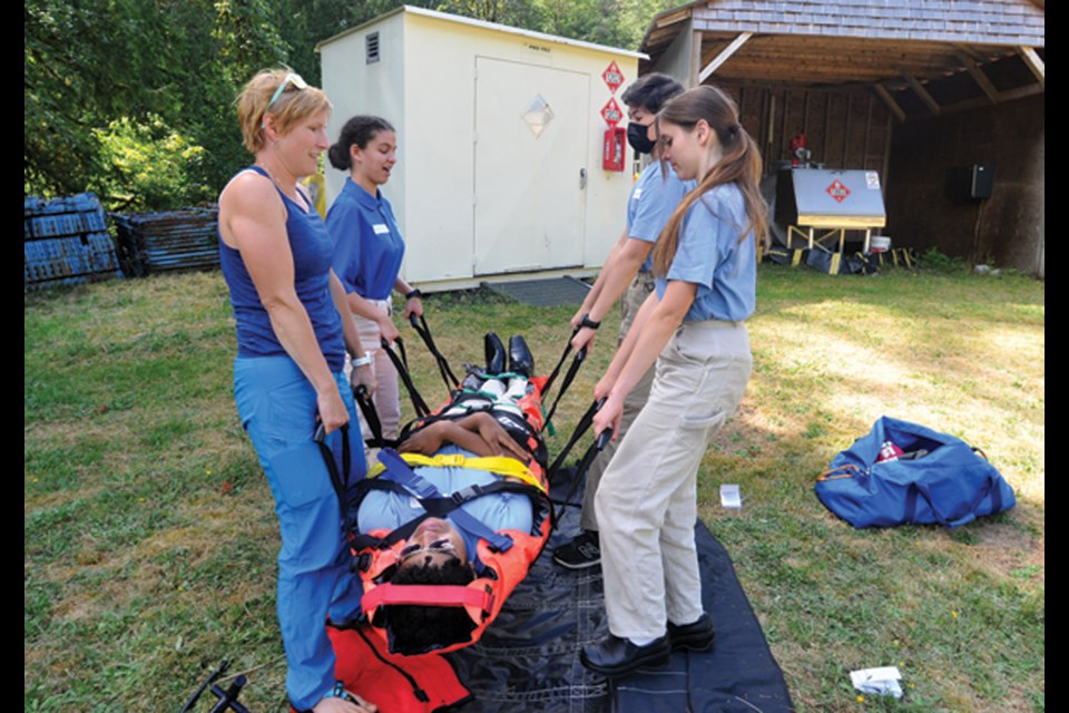 North Shore Rescue member and ER doctor Carolyn Kelly-Smith gets participants to lift a "victim " in a vacuum mattress, part of the West Vancouver Police Youth Academy, Aug. 15, 2022.