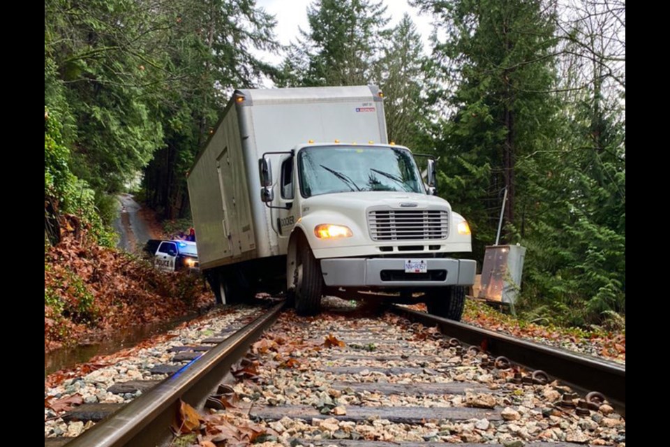 West Vancouver police and Mitchell's Towing help a stuck cube van off the tracks near Horseshoe Bay, on Monday, Nov. 15, 2021.