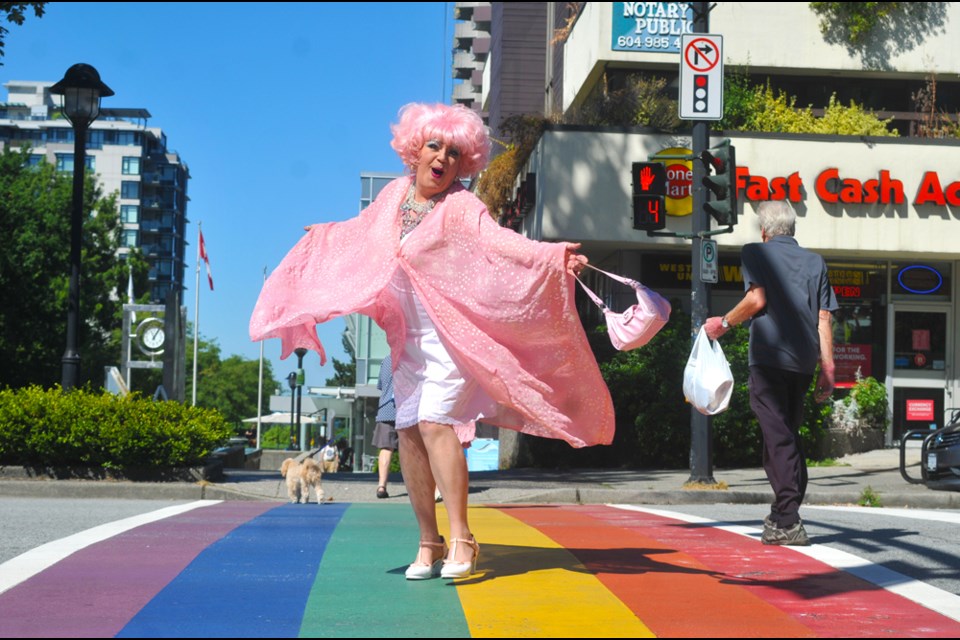 North Shore Pride Alliance founder Chris Bolton, a.k.a. world-famous drag persona Conni Smudge, sashays across the City of North Vancouver's rainbow crosswalk, Aug. 8, 2022, just days after it was defaced with hateful language.