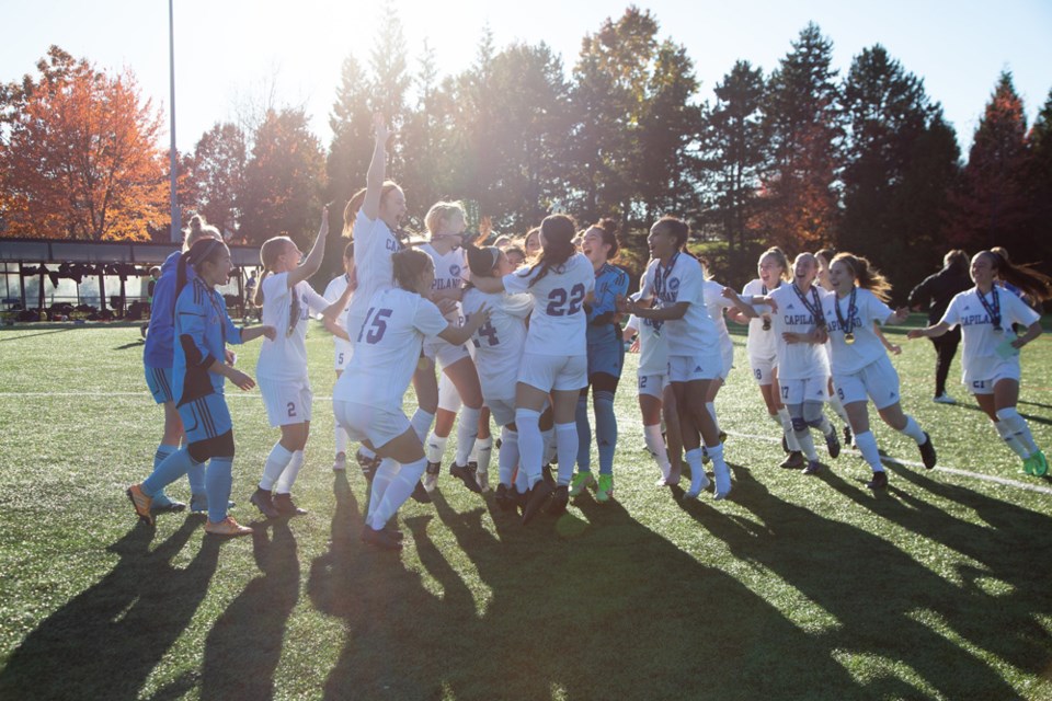 Members of the Capilano Blues women's team celebrate their 2-1 overtime win over the Douglas College Royals in the PacWest championship final played Sunday, Oct. 31, 2021, in Coquitlam.  
