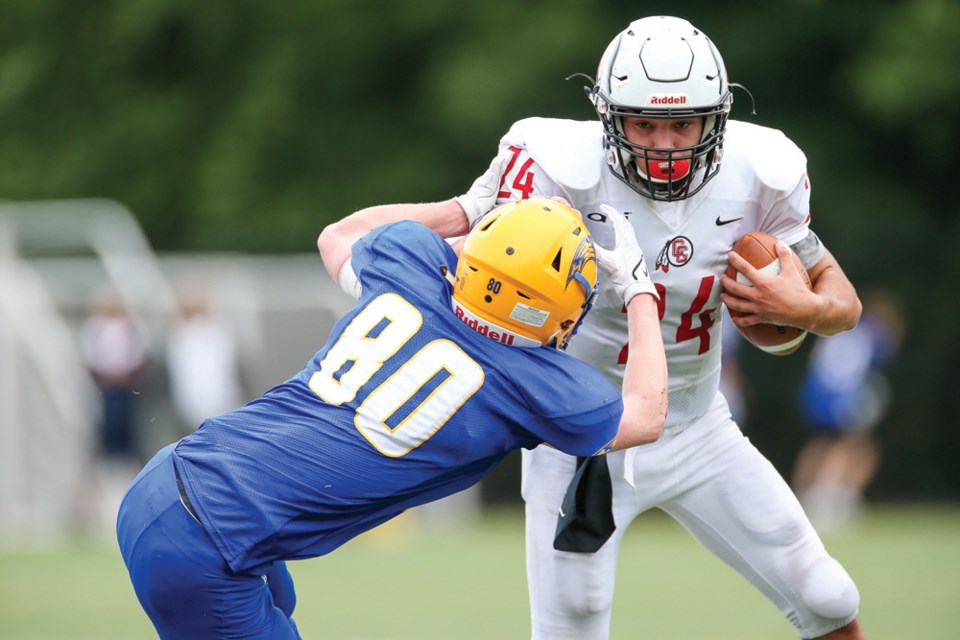 Carson Graham quarterback Logan Mellish fights through a tackle from Handsworth’s Connor Smith in the Buchanan Bowl played Friday at Confederation Field. Mellish was named player of the game as the Eagles won 46-28.  