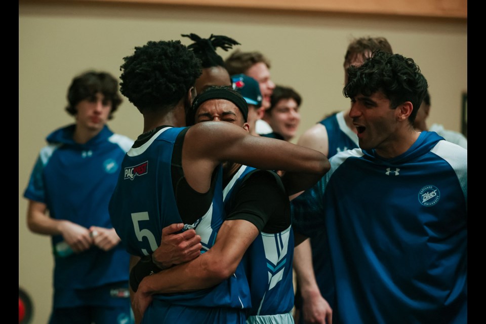 Tyrone Asenoguan and Brendan Bailey of the Capilano University's men's basketball team embrace following a PacWest semifinal win over Camosun College Friday, March 4, at Columbia Bible College in Abbotsford. The win earned the Blues a trip to the national championships.