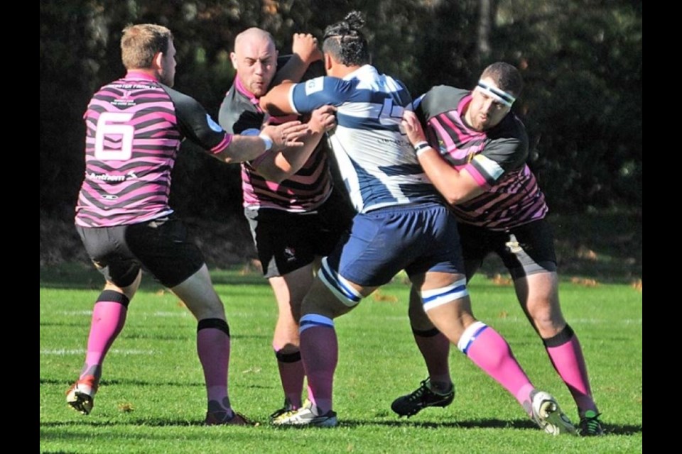 Members of the Capilano Rugby Club's premier men's team make a tackle during 2018's Pink Day game. | Paul McGrath / North Shore News files