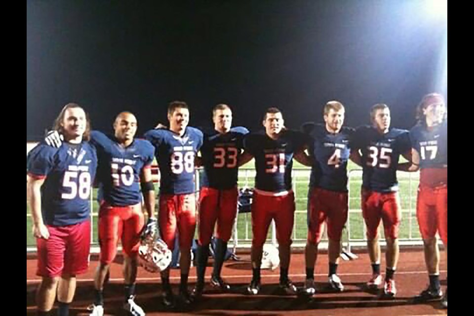 North Vancouver's Dylan Roper (No. 33) poses with teammates during his playing days at Simon Fraser University. Roper is one of the many current and former SFU players stunned by the university’s decision to drop their football program. 