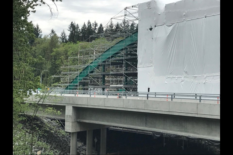 North Vancouver's old Highway 1 Lynn Creek Bridge is emerging from its protective cover in Lions Gate green. May 6, 2021.