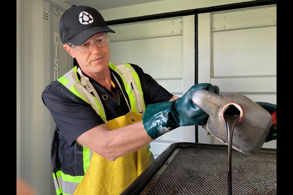 Will Burrows of the B.C. Used Oil Management Association dumps oil into a storage container at an oil recycling centre now open at the North Shore Recycling and Waste Centre, on Thursday, Sept. 16, 2021. The centre is at 30 Riverside Dr., North Vancouver.