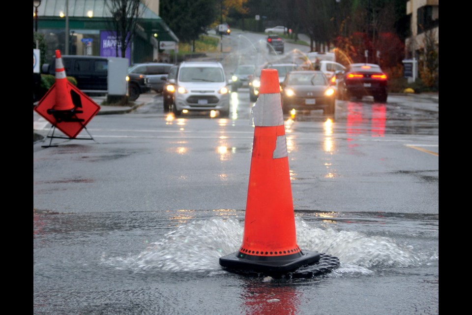 Water flows out of a storm drain onto 15th Street in West Vancouver during a massive storm Nov. 15, 2021.
