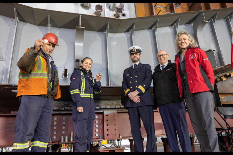 Seaspan workers Dennis Parker and Kathleen Natrall joined Robb Wight, director general of vessel procurement for the Canadian Coast Guard, Seaspan Shipyards CEO John McCarthy and Fisheries Minister Joyce Murray to place coins near to the keel of a new oceanographic science vessel under construction at Vancouver Shipyards Friday.| Seaspan