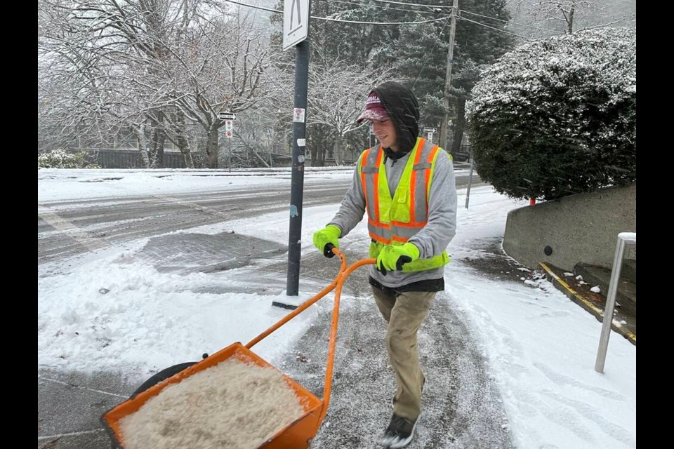 District of West Vancouver worker Lucas Prentice salts and sands sidewalks in Horseshoe Bay on Tuesday afternoon.| Jane Seyd / North Shore News