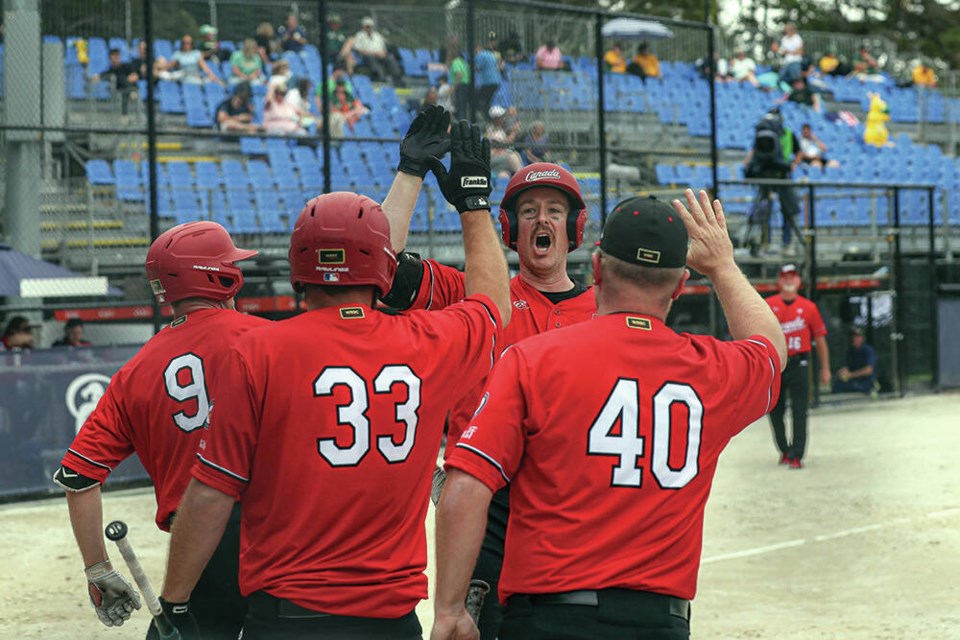 North Vancouver's Derek Mayson celebrates with teammates after crushing a home run for Canada at the 2022 WSBC Men's Softball World Cup held Nov. 26-Dec. 4 in New Zealand. Mayson tied for the tournament lead with three dingers. | WBSC 