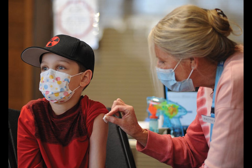 Liam Kenny gets his COVID-19 shot at the Lloyd Avenue kids' vaccination clinic in North Vancouver on Feb. 14, 2022. Both COVID and flu shots are available at the clinic. Families are being encouraged to walk in to get their kids' flu shots this week.| Mike Wakefield, North Shore News
