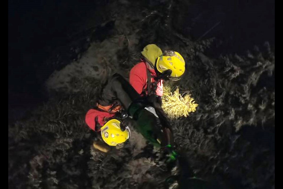 North Shore Rescue volunteers are lowered down to an injured snowboarder in their first-ever night hoist mission in the North Shore Mountains after the man went out of bounds at Cypress Mountain, Dec. 23, 2022. | North Shore Rescue 