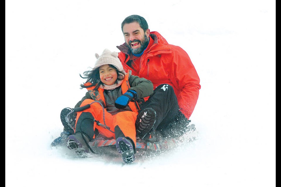 Fred and Emmeline St- Laurent enjoy the recent snowfall on the popular sliding hill at Ray Perrault Park in North Vancouver Dec. 19, 2022. | Paul McGrath / North Shore News 