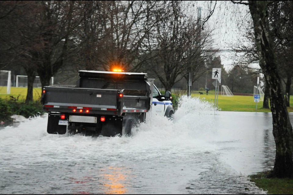 A District of West Vancouver staff truck drives through a flooded parking lot at Ambleside Park on Tuesday. | Paul McGrath / North Shore News 