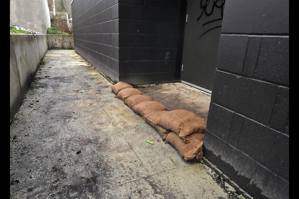A combination of rapid snowmelt and plugged drains resulted in water damage over the winter break to the floors of the gymnasium at Ecole Argyle Secondary in Lynn Valley. Here, sandbags are piled up at west side doorway to gym, on Jan. 2, 2023. | Paul McGrath / North Shore News 