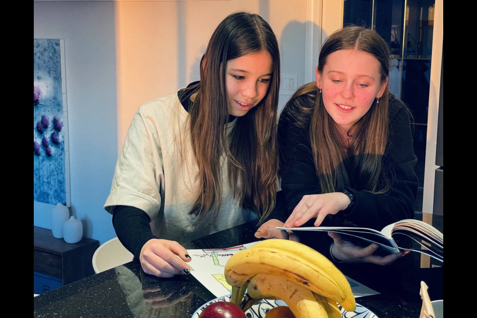 Daryna Dayblo, 12, and Vikki Haraschenko, 14, hang out in the kitchen at Leanne Melnyk's North Vancouver home. Vikki, whose family is still in Ukraine, is living with Melnyk and her family and going to school in North Vancouver. | Jane Seyd / North Shore News