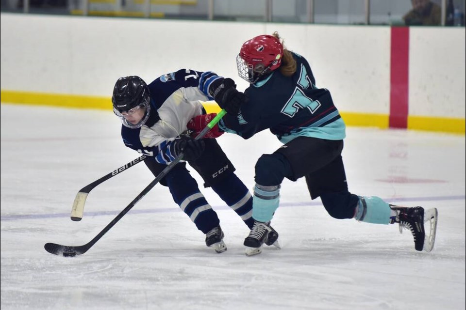 North Shore Rebels forward Nicole Charlton battles for the puck against Jackie Lang of the Fraser Valley Jets. | Don Bartel / SCWHL 