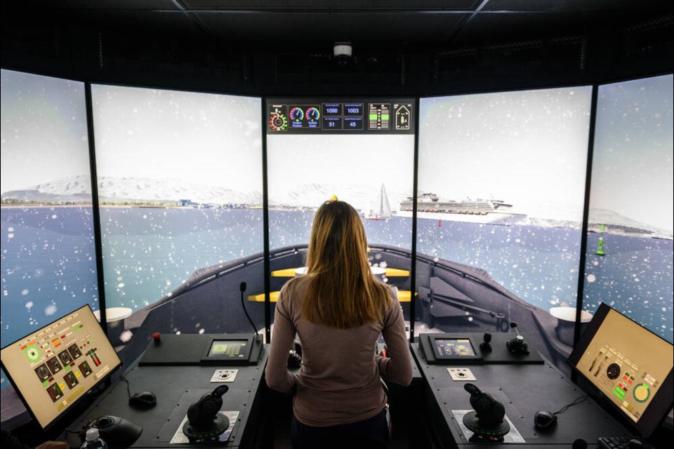 A woman attending Seaspan Marines open house Feb. 28 tries out a state-of-the-art tugboat simulator. | Mike Savage / 21stops 