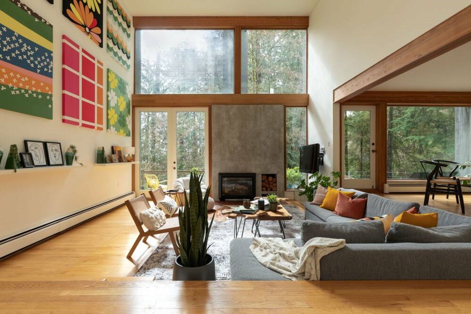 The living room of the Cheng home features large windows, natural wood finishings and a sunken area. | West Coast Modern