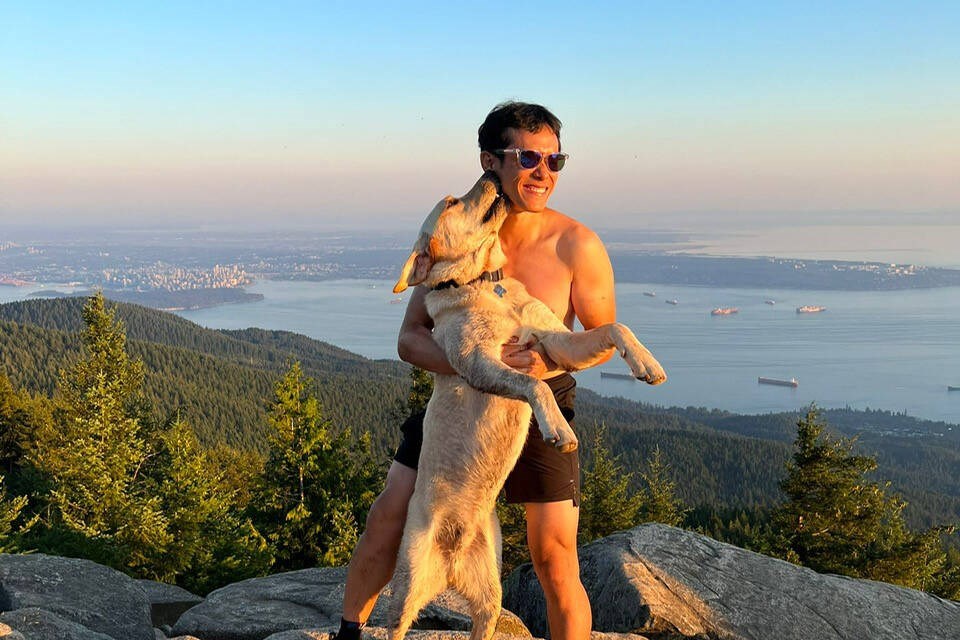Keen Lau and his dog Loki embrace on a hike overlooking West Vancouver. | Lisa Park 