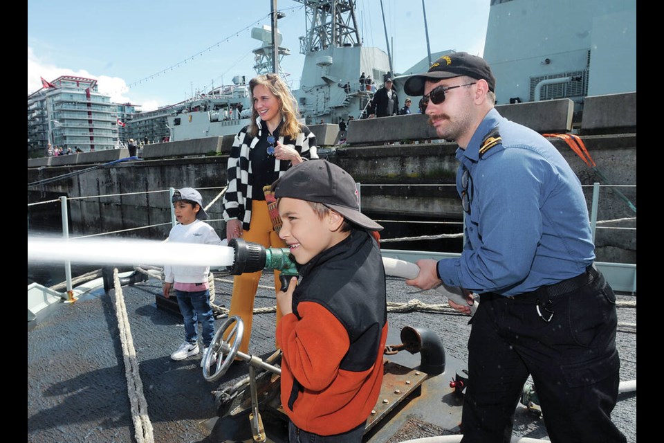 Six-year-old Oliver Sadeghi-Yekta tries his fire suppression technique on the ORCA Class Raven. | Paul McGrath / North Shore News 