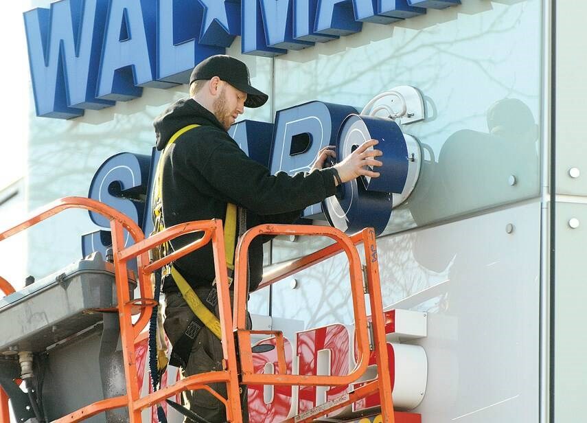 A worker replaces a Sears sign at Capilano Mall, after the department store went bankrupt in October 2017. | North Shore News files 