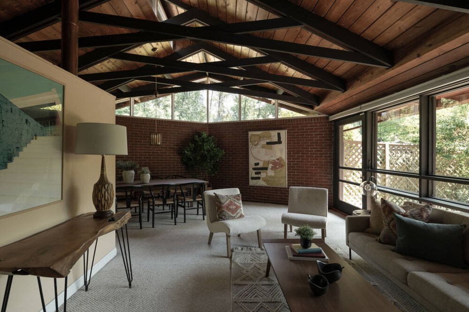 The living area of the Flying Arrow house has exposed scissor trusses, a brick wall and clerestory windows. | West Coast Modern 