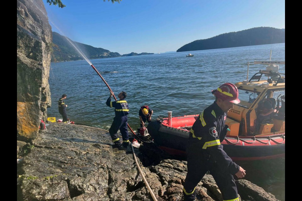 Royal Canadian Marine Search and Rescue volunteers, Lions Bay Fire Rescue and BC Wildfire Service members work to put out a wildfire burning just south of Lions Bay, Sunday, June 5, 2023 | RCMSAR01 