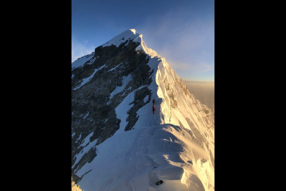 Along the summit ridge to the peak of Mount Everest is a single safety rope shared by climbers travelling in both directions. | Bruce McAdie 