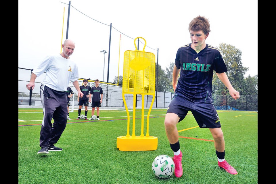 Argyle senior boys soccer team member Aidan Best takes part in drills under the eye of head coach Darren Rath on the newly-opened Ecole Argyle Secondary artificial turf field. | photo Paul McGrath / North Shore News 