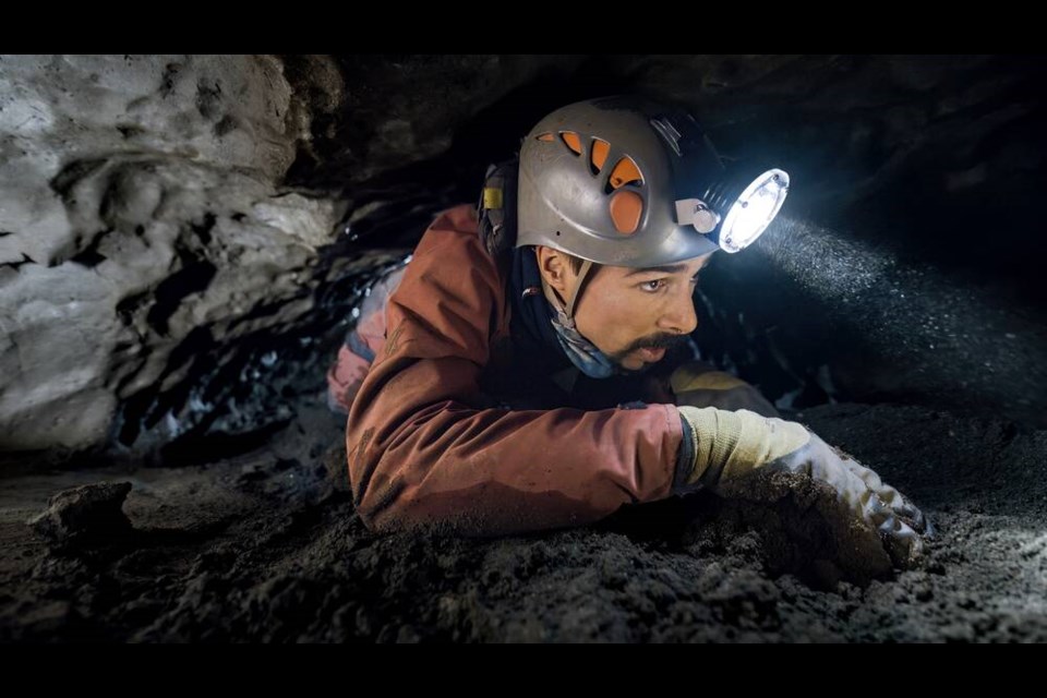 Expedition leader Franck Tuot crawls along an underground passage on Vancouver Island. | Courtesy of Subterranean film 