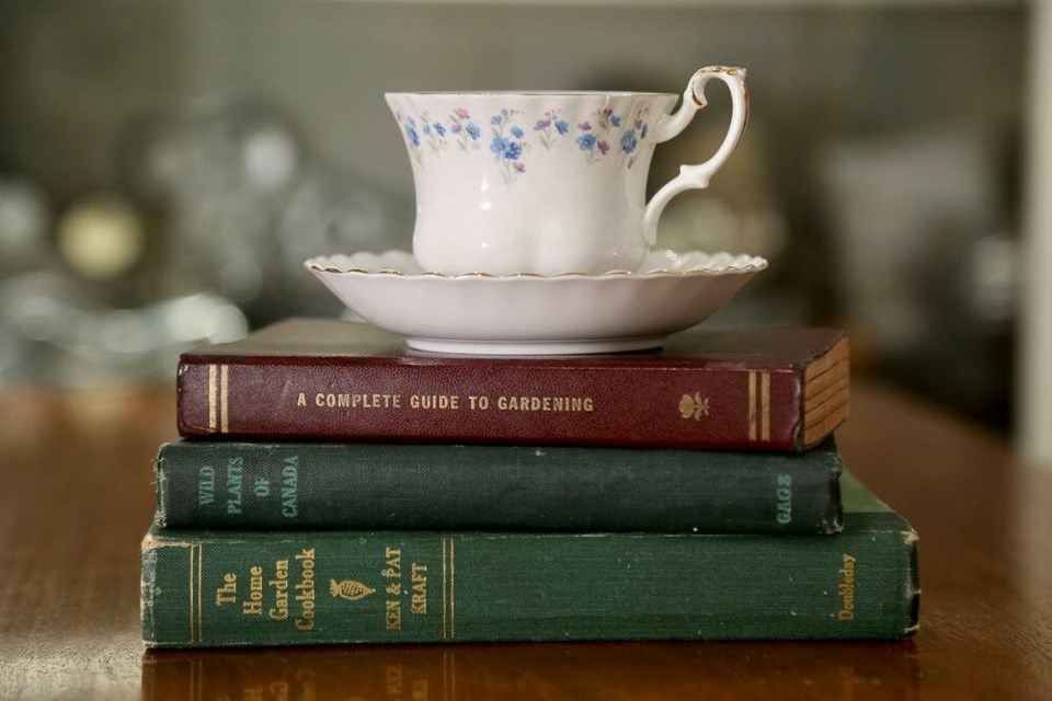 Old-school gardening books and a vintage forget-me-not teacup say ‘relax by the fire.’ | Laura Marie Neubert 