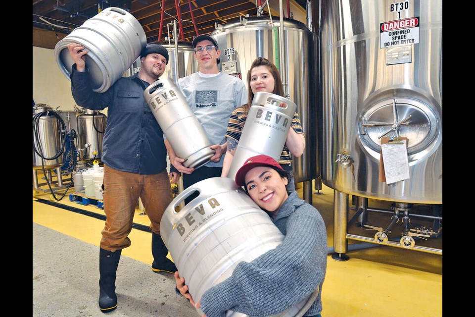 Co-owners of Beva Brewing and Blending cradle kegs at their newly opened brewery on Pemberton Avenue in North Vancouver: Octavio Pauley, Graham Elliott, Desha Miciak and Morgan Miller. | Paul McGrath / North Shore News
