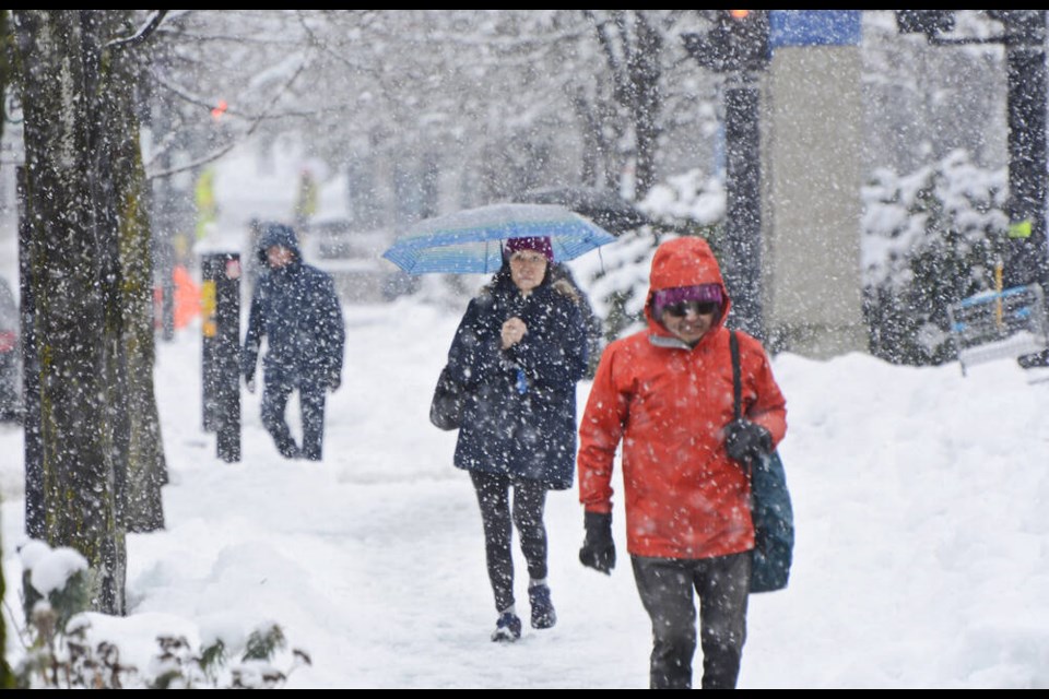 Pedestrians walk in the snow along North Vancouver’s Lonsdale Avenue on Feb. 28, 2023. Snow is expected to return to the North Shore on Thursday. | Nick Laba / North Shore News 