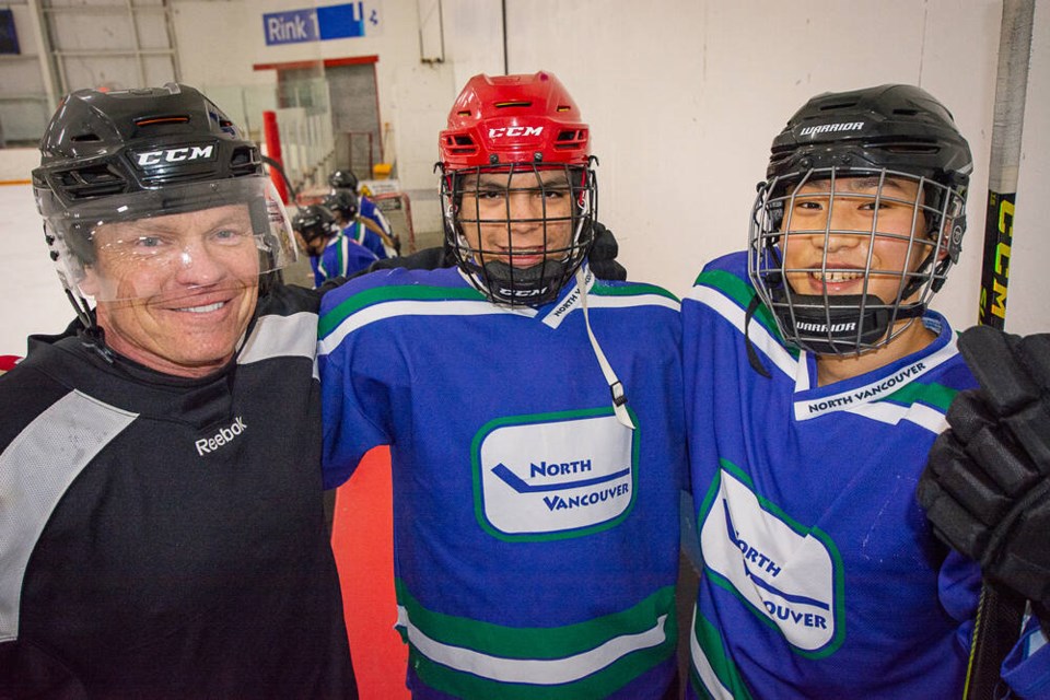 Hockey Heroes founder and Hollyburn youth services manager Steve Kirkby gets ready to hit the ice with Grade 12 Mountainside Secondary students Ben and J.C. | Nick Laba / North Shore News 