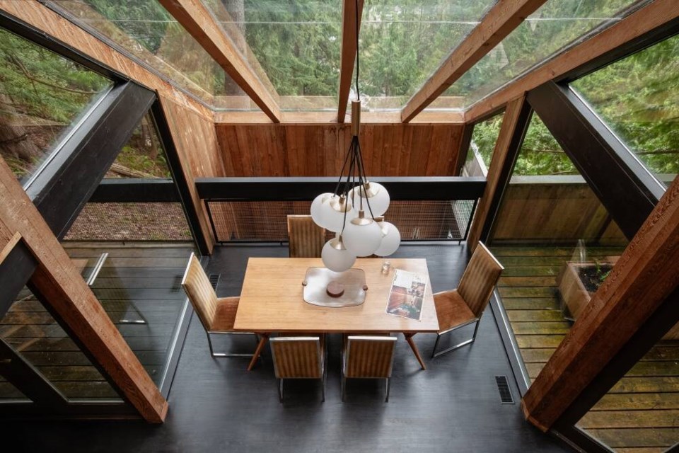 Dramatic window panes light the dining area and provide stunning exterior views in this unique Lions Bay home. | Courtesy of West Coast Modern 