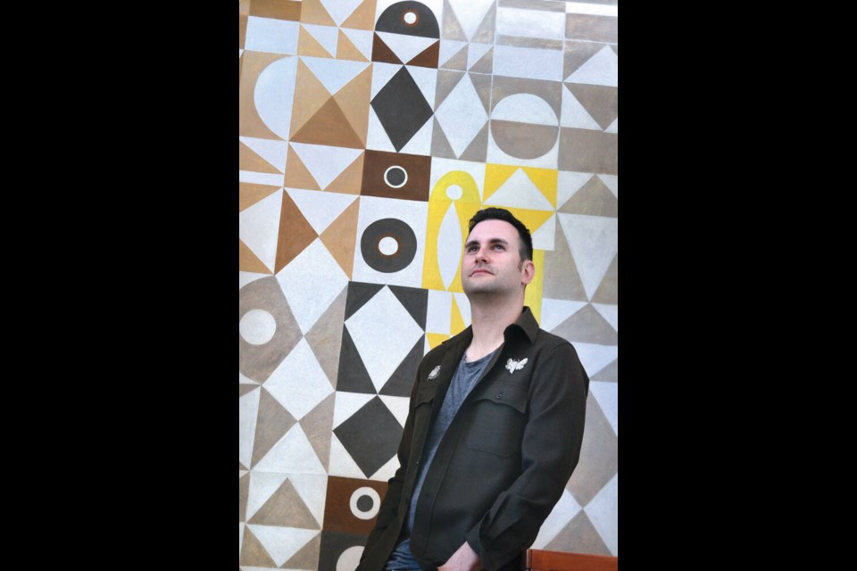 Binning House owner Jesse Saniuk stands proudly with the newly restored mural by artist B.C. Binning. The work by conservator Cheryle Harrison has now been honoured with an award by Heritage B.C. | Paul McGrath / North Shore News 